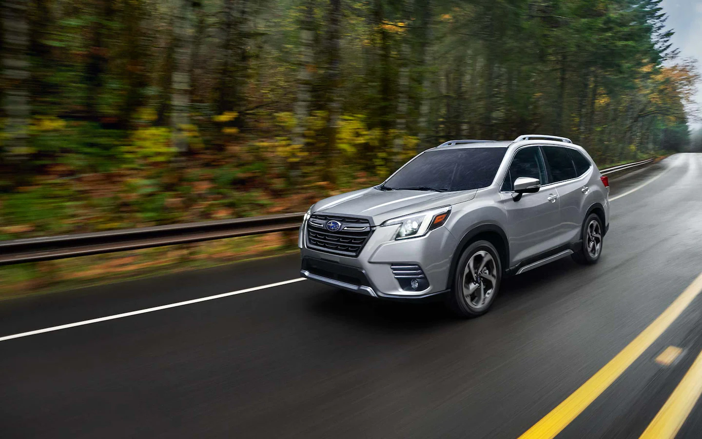 A 2022 Forester driving on a wet country highway.