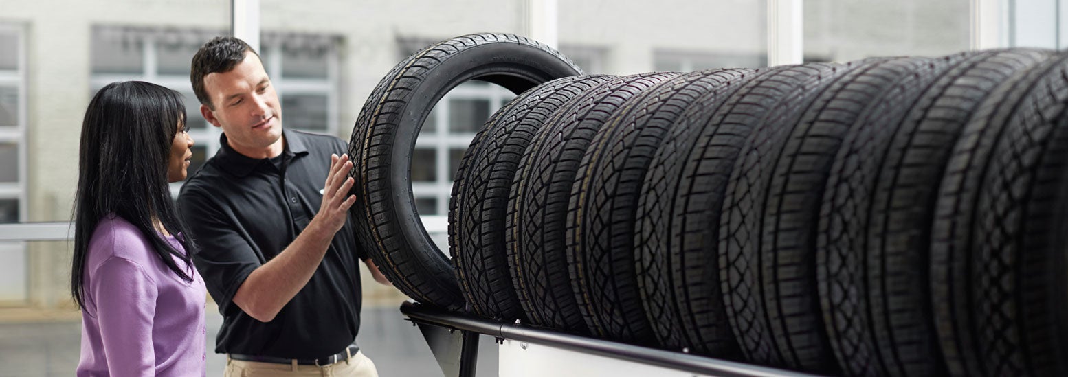 Subaru service representative showing customer a tire. | Subaru of Naples in Naples FL