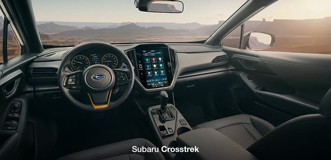 Subaru Crosstrek interior featuring the steering wheel, digital displays, center touchscreen, and front seating.