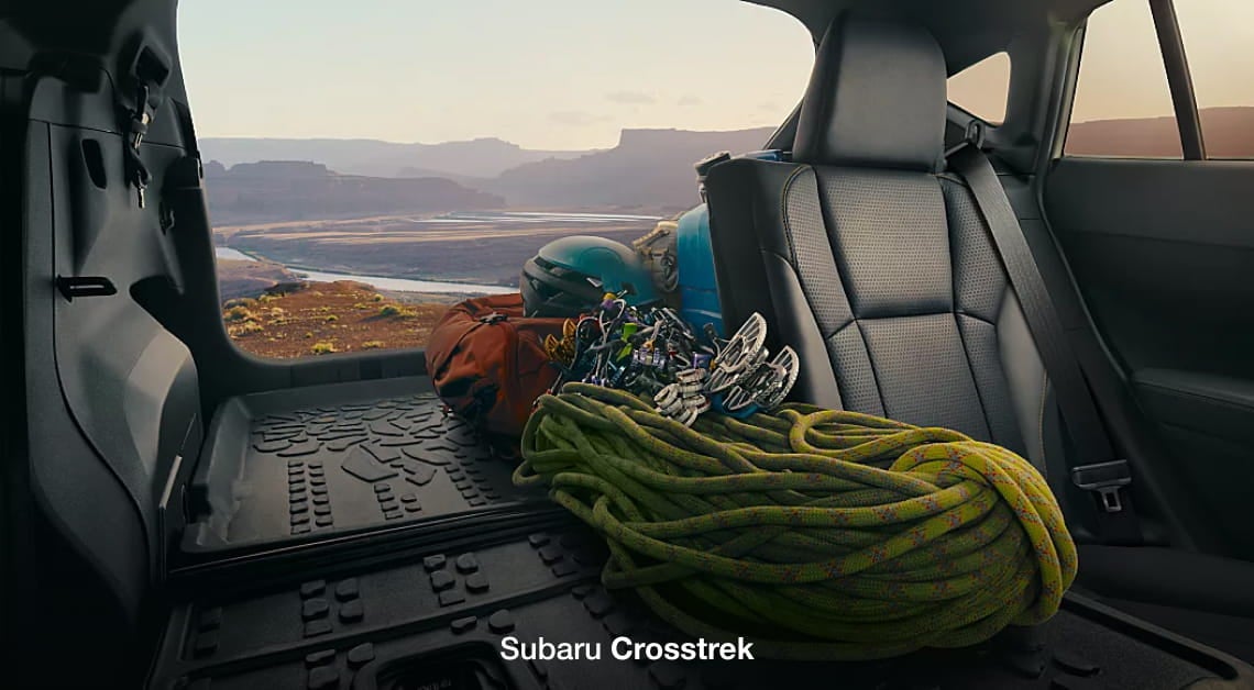 Subaru Crosstrek cargo area loaded with climbing gear, including ropes, helmets, and equipment bags.