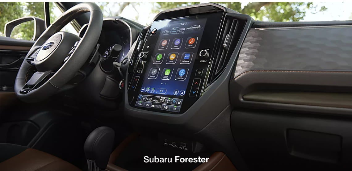 Subaru Forester interior featuring the steering wheel, large center touchscreen, climate controls, and dashboard details.